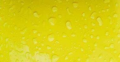 Raining water drop on yellow plastic table  after rainy day for background. Art or Abstract, Wallpaper, Colorful and Pattern photo
