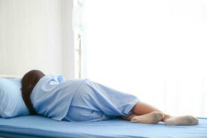 hembra paciente siendo tratado en hospital mentira en el cama en el paciente habitación. concepto de médico servicios en hospitales salud seguro. Copiar espacio foto