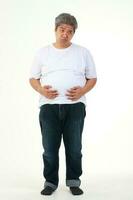 A fat man wearing a white shirt held his belly. standing on a white background. weight loss concepts, health problems of obese people photo