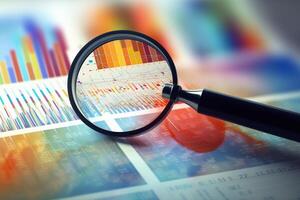 Business intelligence concepts illustrated through a magnifying glass hovering over a data chart, symbolizing the extraction of insights and meaningful information from data photo