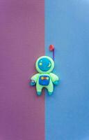 Astronaut made of light Plasticine, Cute and beautiful cosmonaut in a helmet with antenna, Blue suit on bright background photo