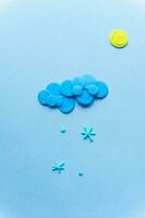 Plasticine sun with cloud and snow. Modeling clay handmade weather on blue background. photo