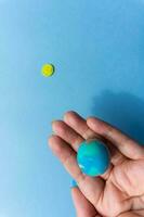 Woman holding plasticine model of planet Earth on blue background and sun photo