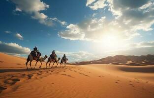 People riding camels on a sand dune in the desert photo