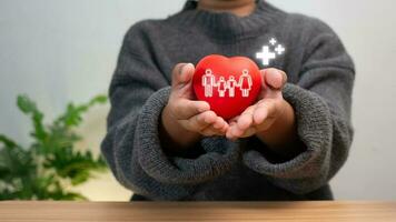 Good health and insurance concept, health insurance concept. Boy hand holding plus sign and red heart, positive volume. photo