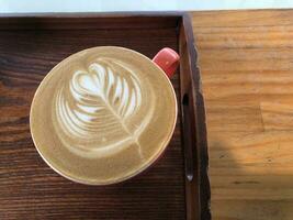 A latte with a wood grain table photo