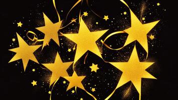 Glittering gold powder stars with ribbons, dark background photo