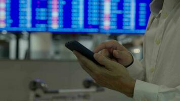 Business man using mobile phone to book plane ticket through online application, sitting on travel checking travel time on board at airport, travel, payment, due, booking, online, check in video