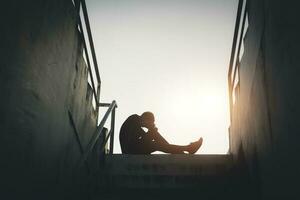 Silhouetted of sad photo. Lonely man sitting on the floor.He is unhappy and sad.He is depression.unlove,unhappy,fail.Photo concept for Disease and depression. photo