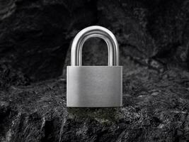 Metal padlock on black coal background photo