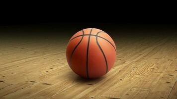 A basketball with a dark background on a hardwood gym floor photo