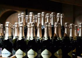 Bottles of champagne on the counter. Shelves with wine and champagne in the store winery. Counter at the winery. photo