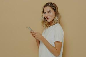Joyful student browsing phone, looking at camera, modern tech concept photo
