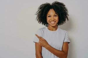 Beautiful black woman cheerful with beaming smile on her face pointing with hand and finger up photo