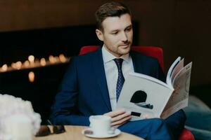 Serious entrepreneur reads mag, coffee shop, formal suit, dinner break. Business and lifestyle concept. photo