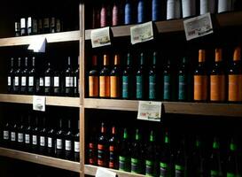 Shelves with wine and champagne in the store winery. Counter at the winery. photo