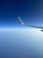 View from the airplane window. Beautiful cloudscape with blue sky. Wonderful panorama above white clouds as seen through window of an plane. photo