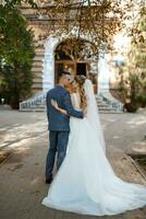 recién casados caminar en el ciudad cerca antiguo edificios foto