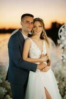 bride and groom against the backdrop of a yellow sunset photo