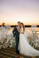 bride and groom against the backdrop of a yellow sunset photo