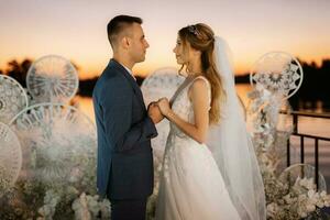 bride and groom against the backdrop of a yellow sunset photo