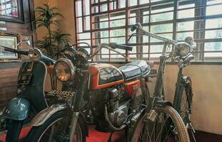 Toba, Indonesia, June 2023 - a collection of antique TB Silalahi motorbikes, Vespa and Honda CB and ontel bikes.  three antique vehicles in the TB Silalahi museum. photo