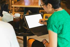mujer mano utilizando aguja bolígrafo en digital tableta trabajando en el cafetería. foto