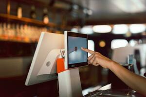 Woman hand doing process payment on a touchscreen cash register. photo