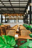 Wooden table and rattan chairs at open cafe outdoor. photo