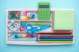 elegante de colores papelería. lugar de trabajo. organización de un cajón a el lugar de trabajo. almacenamiento y orden de oficina suministros. concepto espalda a escuela. foto