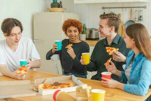 Home party Friends spending time together having fun laughing communicating at home. Happy diverse group eating pizza drinking beer or lemonade. Mixed race young buddies best friends enjoying weekend. photo