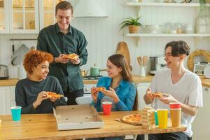 hogar fiesta. lleno de alegría diverso amigos comiendo ordenado Pizza para hogar fiesta. contento grupo mezclado carrera joven amigos disfrutando gasto gratis fin de semana hora juntos teniendo divertido riendo bromas comunicado. foto