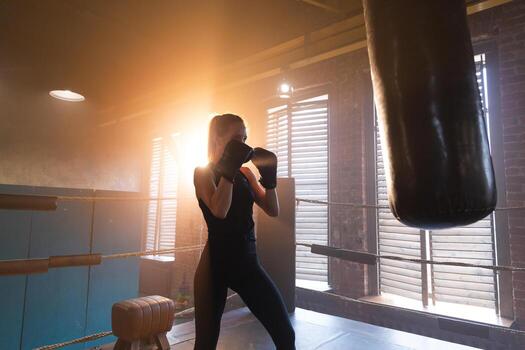mujer yo defensa niña fuerza. fuerte mujer combatiente formación puñetazos en boxeo anillo. sano fuerte niña puñetazos boxeo bolsa. formación día en boxeo gimnasia. fuerza ajuste cuerpo rutina de ejercicio capacitación. foto