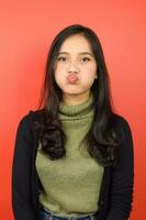 Blowing Kiss To You Of Beautiful Asian Woman Isolated On Red Background photo