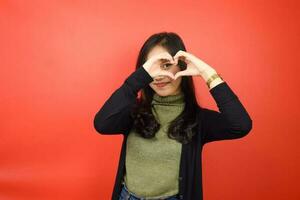 Showing Love Sign Of Beautiful Asian Woman Isolated On Red Background photo