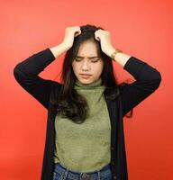 Suffering Headache Gesture Of Beautiful Asian Woman Isolated On Red Background photo