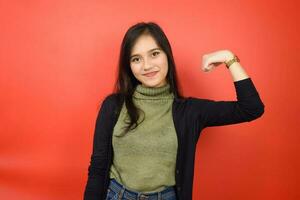 Rise Arms and showing strength Of Beautiful Asian Woman Isolated On Red Background photo