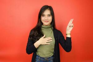 Swearing Gesture, Make an Oath Of Beautiful Asian Woman Isolated On Red Background photo