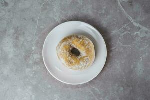Delicious donuts with powdered sugar on plate photo