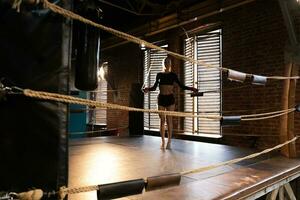 Woman fighter girl power. Woman fighter jumping rope on boxing ring. Strong powerful girl female athlete does cardio workout. Training day in boxing gym. Strength fit body training active exercise photo