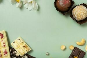 Frame made from craft chocolate candies, mini chocolates and nuts flat lay, top view photo