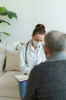 Female doctor examining older senior man in doctor office or at home. Old man patient and doctor have consultation in hospital room. Medicine healthcare medical checkup. Visit to doctor. photo