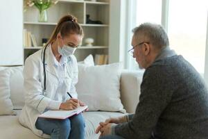 Female doctor examining older senior man in doctor office or at home. Old man patient and doctor have consultation in hospital room. Medicine healthcare medical checkup. Visit to doctor. photo