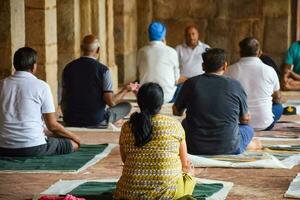 New Delhi, India, May 31 2023 - Group Yoga exercise class for people of different age in Lodhi Garden, International Yoga Day, Big group of adults attending a yoga class in park photo