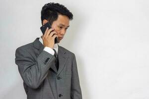 asian businessman looking at mobile phone stressed at work and worried photo