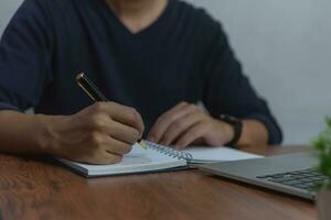 empresario trabajando a escritorio, utilizando bolígrafo y papel a escritura y planificación tomar notas conceptos negocio organización, o gestión, estrategia, comunicación. foto