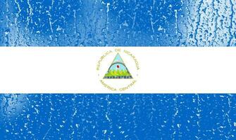 3D Flag of Nicaragua on a glass with water drop background. photo