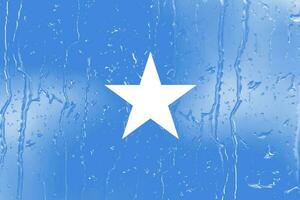 3D Flag of Somalia on a glass with water drop background. photo