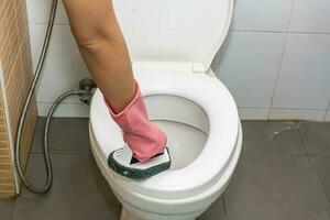 Woman cleaning toilet photo