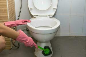 Woman cleaning toilet photo